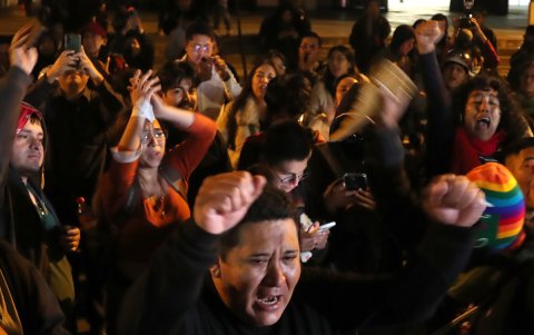 Personas celebran a las afueras de la Embajada de Ecuador este jueves, en Lima (Perú).