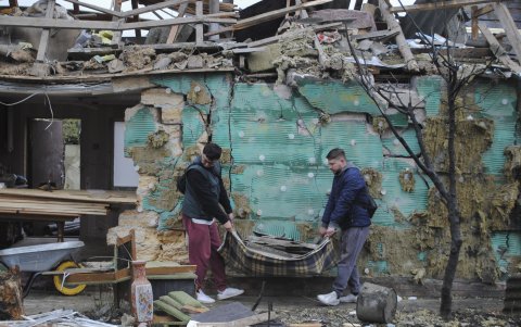 Ciudadanos limpian los escombros de un reciente ataque ruso.