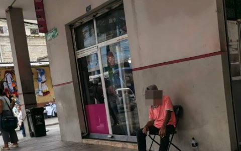 Un adulto bebe licor en la vereda mientras conversa consigo mismo en la calle Pío Montúfar, en el centro de Guayaquil.