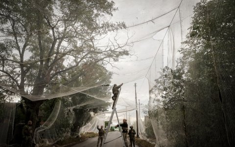 Militares ucranianos cubren la carretera cona red para proteger los vehículos de los ataques con drones en un lugar no revelado en la región de Donetsk.