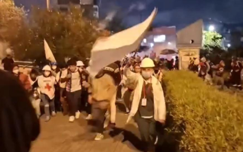 Una brigada de paramédicos corre junto a estudiantes, en medio de bombas lacrimógenas, en el interior de la Universidad Central.