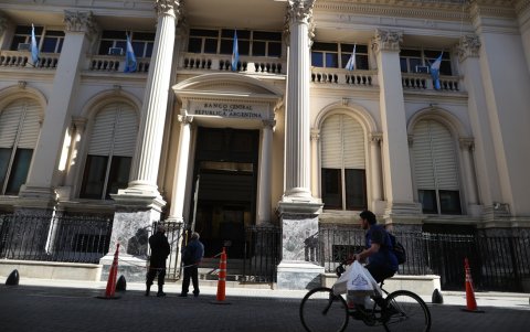 Varias personas cruzan frente al Banco Central de la República de Argentina.