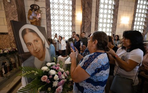 Personas toman fotografías a una imagen de Santa Carmen Rendiles durante una misa en su honor este domingo, en Caracas (Venezuela).