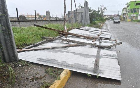 Una valla caída debido a los vientos preliminares al inminente paso del huracán Melissa este lunes, en la playa pesquera de Hellshire, en Portmore (Jamaica).