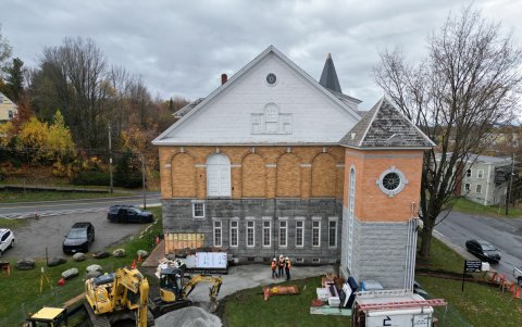 Vista aérea muestra las obras en marcha para construir entrada lateral canadiense a la Biblioteca Haskell transfronteriza en Stanstead, en la frontera entre Canadá y Estados Unidos marcada por rocas.