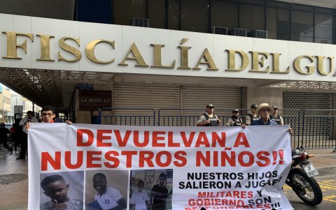 Archivo del 23 de diciembre de 2024 que muestra dos personas sosteniendo un cartel en los exteriores de la Fiscalía Provincial del Guayas.