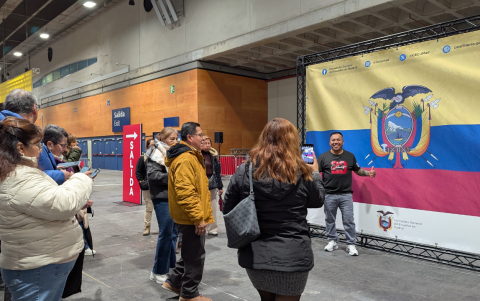 En el recinto electoral de Madrid, los votantes aprovechan la bandera de gran formato para tomarse fotografías durante la jornada.