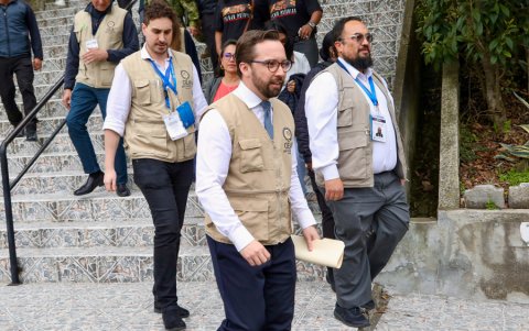 El jefe de misión de la OEA, Nicolás Albertoni (c), realiza un recorrido por un colegio para verificar que el proceso de referéndum y consulta popular se desarrolle con normalidad, este domingo, en Quito (Ecuador).