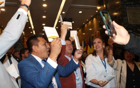 Asambleístas y militantes de Revolución Ciudadana levantan ejemplares de la Constitución de Montecristi en el hall de la Asamblea Nacional, celebrando el triunfo del “No”.