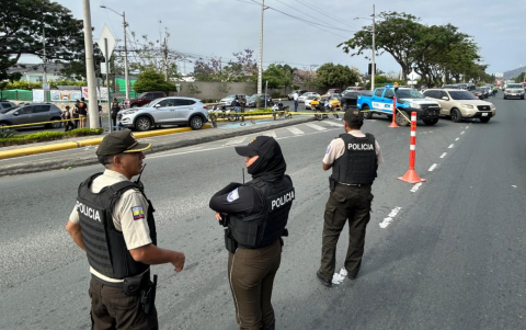 Policías inspeccionan la zona donde el vehículo fue atacado en la vía a la costa.