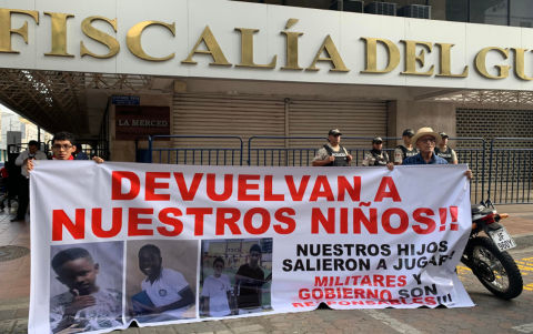 Dos personas sostienen un cartel frente a la Fiscalía del Guayas, en Guayaquil, el 23 de diciembre de 2024