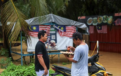 Los propietarios de tiendas empacan sus pertenencias mientras sus locales se ven afectados por las inundaciones en Klang, a las afueras de Kuala Lumpur, Malasia, el 24 de noviembre de 2025.