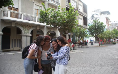 Cobos junto a sus amigas, revisando las fotos tomadas.