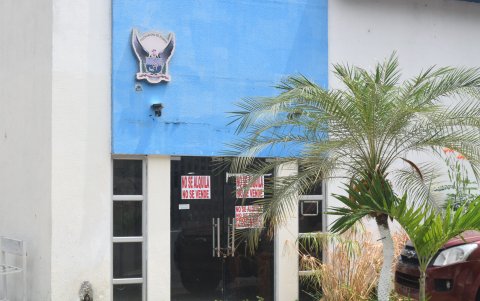 Puerta principal de UPC cerrado con cadena, cubierta de carteles escritos a mano que advierten “No se alquila, no se vende”