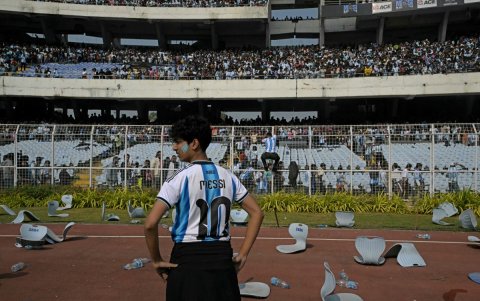 Un aficionado se encuentra entre sillas rotas mientras el delantero argentino número 10 del Inter de Miami, Lionel Messi, sale del Estadio Salt Lake en Calcuta.