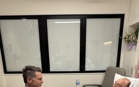 Foto del líder político de Nueva Gales del Sur, Chris Minns, que lo muestra visitando en el hospital a Ahmed al Ahmed, el hombre que desarmó a uno de los autores del atentado.