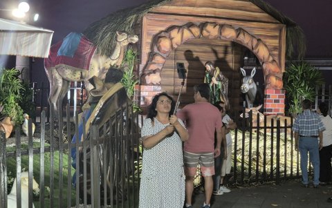 Una ciudadana se detiene para fotografiarse junto al pesebre del Malecón 2000, en el centro de Guayaquil.