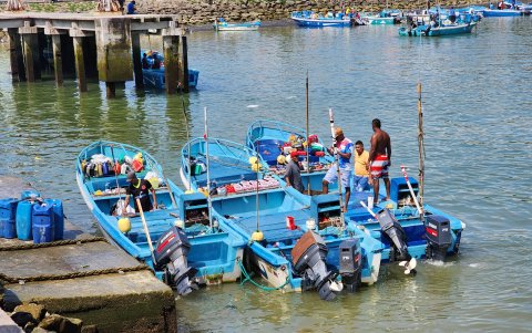 Hombres alistan embarcaciones de pesca artesanal, en el Puerto de Esmeraldas.