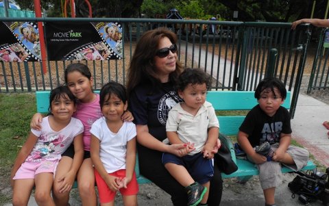La nicaragüense Nora Sandigo, de 48 años, de Nicaragua, se sienta en un banco de un parque con cinco de los 817 niños sobre los que tiene tutela en vivo, en Miami.