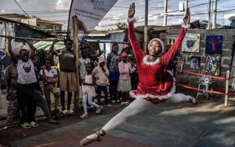 Shelly Ajiambo, estudiante de ballet, baila en el escenario durante la actuación anual navideño del Proyecto Elimu en el asentamiento informal de Kibera, en Nairobi, el 23 de diciembre de 2025.