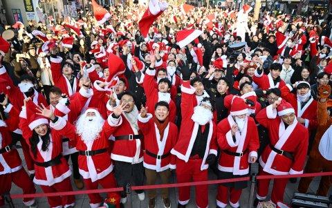 Voluntarios surcoreanos vestidos de Papá Noel lanzan gorros al aire durante una ceremonia de lanzamiento antes de entregar regalos a unos 800 niños desfavorecidos en Seúl.