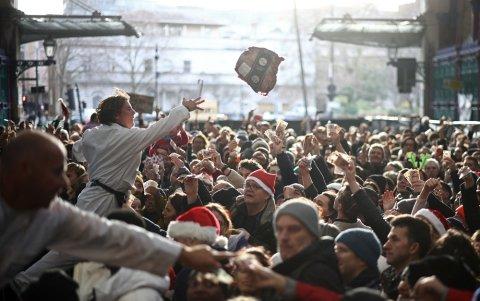 Los trabajadores venden cortes de carne, incluidas piezas de res, durante la tradicional subasta de Nochebuena en el mercado de carne de Smithfield en la ciudad de Londres.