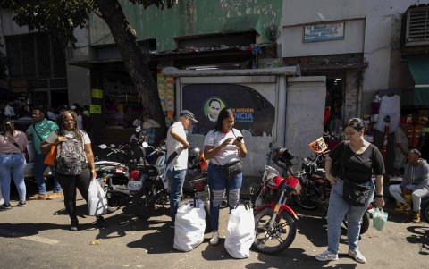 Personas esperan transporte público el 22 de diciembre de 2025, en Caracas (Venezuela).