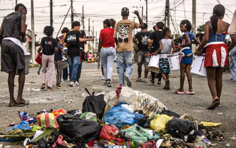 INTEGRANTES DE LA BATUCADA POPULAR PASAN JUNTO A UN BOTADERO DE BASURA EN SOCIO VIVIENDA, QUE ESTÁ FRENTE A UN COLEGIO AG-EXPRESO