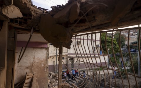 Personas observan un edificio afectado por un explosivo, este domingo en Catia La Mar (Venezuela).