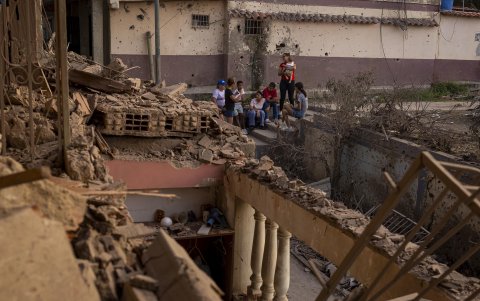 Algunos residentes de viviendas alcanzadas por los ataques de Estados Unidos contra varias zonas de Venezuela, incluida Caracas, recorren un barrio.