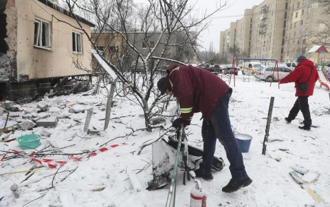 Un trabajador comunitario ucraniano recoge restos del dron ruso en el lugar del ataque con dron al edificio residencial en Kiev, Ucrania, el 9 de enero de 2026, en medio de la invasión rusa.