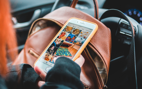 Referencial.Un adolescente revisa redes sociales desde el auto, expuesto a contenidos que promueven estilos de vida ostentosos.