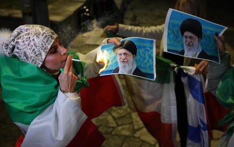 Una integrante de la comunidad iraní israelí quema una foto del líder supremo de Irán, Ali Khamenei, durante una protesta en apoyo al pueblo iraní en Holon (Israel).