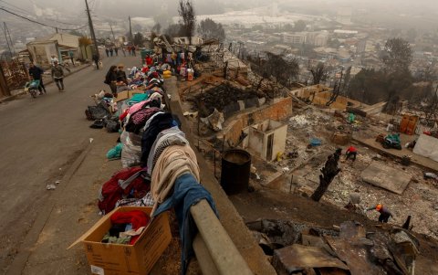 La ropa se apila al costado de una calle mientras los residentes limpian los escombros de las casas destruidas por un incendio forestal en Lirquen, un pueblo en Penco cerca de la ciudad de Concepción.