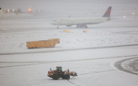Se ve una máquina quitanieves trabajando mientras un Airbus A321 de Delta Airlines rueda para despegar en la pista del aeropuerto LaGuardia en Nueva York el 25 de enero de 2026.