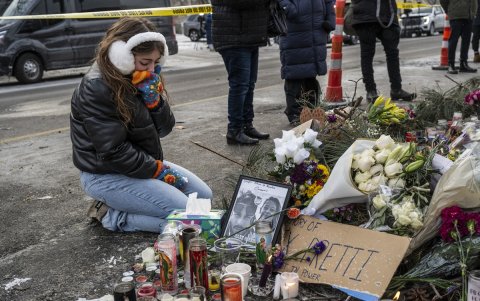 Una residente local se arrodilla y llora mientras visita un monumento improvisado en la zona donde Alex Pretti fue asesinado a tiros por agentes federales de inmigración en Mineápolis.