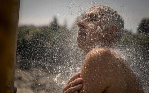 En la imagen de archivo, un hombre se refresca en una ducha en las termas de A Chavasqueira, en Ourense, España.