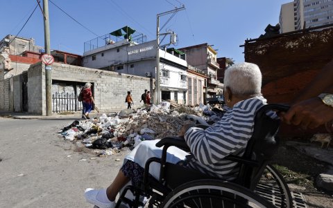 Un grupo de personas transitando por una calle con basura, en La Habana (Cuba).