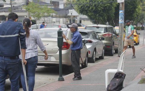 Algunos 'cuidacarros' se encargan de recargar el parquímetro a conductores que se lo encargan.