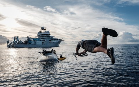 Una tripulación del OceanXplorer, un buque de investigación operado por la organización marina sin fines de lucro OceanX, salta al mar.