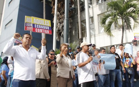 Simpatizantes del alcalde de Guayaquil, Aquiles Álvarez sostienen carteles durante una protesta este martes, en Guayaquil (Ecuador).
