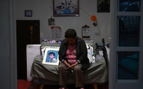 Hermencia Vega, madre de Diuviseldo Torres, víctima de desaparición forzada, se sienta junto a una foto de él.