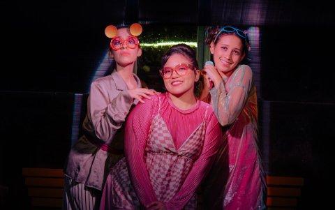 Tres mujeres esperan un bus hacia un “gritadero” en un futuro incierto. La obra cuestiona, desde el arte, cómo la sociedad regula las emociones y la comunicación.