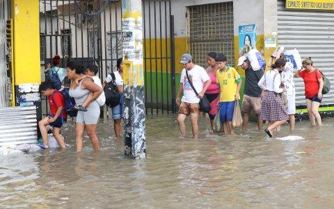 Vías. Las calles y veredas lucen completamente inundadas. Los padres cargan a sus hijos para evitar accidentes.