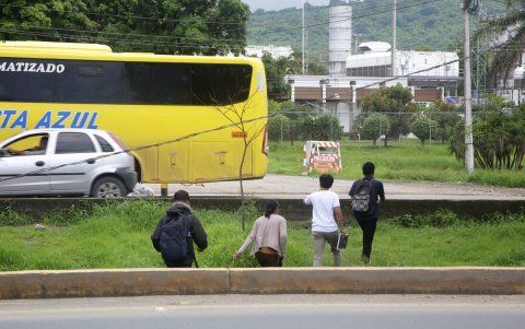 Los estudiantes cruzan a diario por un peligroso parterre en el kilómetro 19,5 de la vía a la costa para alcanzar un bus.