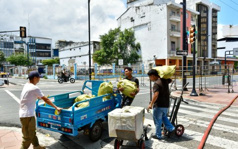 Empleados de los negocios que están en los alrededores del Multicomercio trasladan la mercadería para evitar que se dañe, mientras se define la demolición de la edificación.