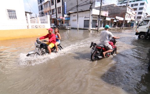 Los motociclistas son los únicos que se arriesgan a pasar a causa de los estragos de las inundaciones en  las calles de Milagro