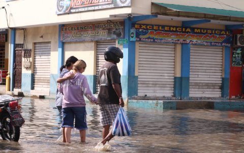 Las personas pasan las calles inundadas con miedo a caerse en un hueco y los negocios permanecen cerrados.