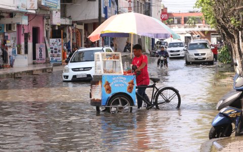 Las personas pasan las calles inundadas vendiendo, pero los compradores son pocos