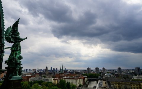 Estatuas de cobre que representan ángeles decorando la cúpula de la Catedral de Berlín contemplan el río Spree.
